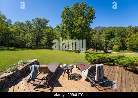 Ein paar moderne Liegestühle auf einer Terrasse in einem Landhaus. Stockfoto