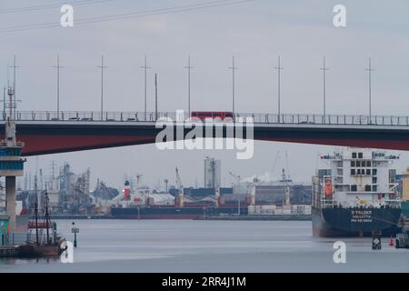 Schiffe im Hafen von Melbourne auf dem Yarra River mit Fahrzeugbewegung über die Bolte Bridge, Melbourne Australien. Stockfoto