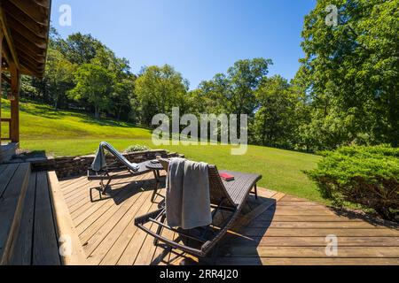 Ein paar moderne Liegestühle auf einer Terrasse in einem Landhaus. Stockfoto