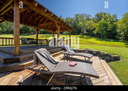 Ein paar moderne Liegestühle auf einer Terrasse in einem Landhaus. Stockfoto