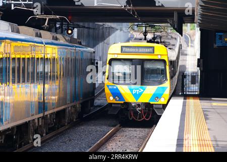 Öffentliche Verkehrsmittel Melbourne zeigt einen elektrischen Personenzug, der in einen Vorortbahnhof fährt. Stockfoto