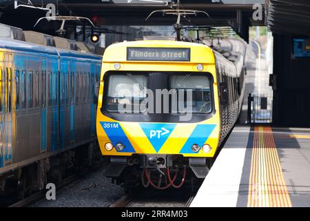 Öffentliche Verkehrsmittel Melbourne zeigt einen elektrischen Personenzug, der in einen Vorortbahnhof fährt. Stockfoto