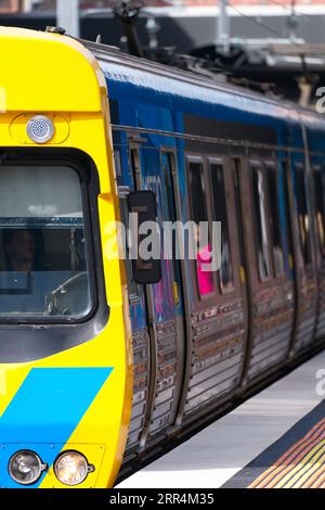 Öffentliche Verkehrsmittel Melbourne zeigt einen elektrischen Personenzug, der in einen Vorortbahnhof fährt. Stockfoto