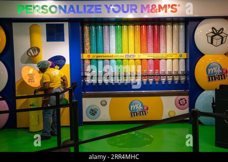 New York, USA - 22. Juli 2023: Dispenser voller verschiedener Farben und Geschmacksrichtungen von Süßigkeiten in einem M&M's Store in New York. Stockfoto