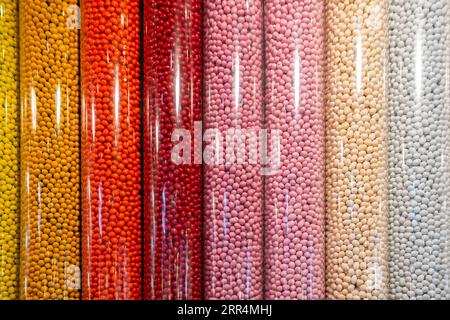 New York, USA - 22. Juli 2023: Dispenser voller verschiedener Farben und Geschmacksrichtungen von Süßigkeiten in einem M&M's Store in New York. Stockfoto