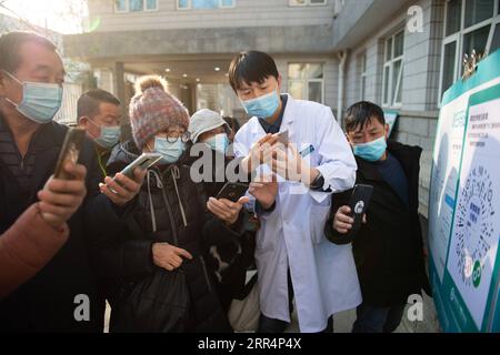 201210 -- PEKING, 10. Dezember 2020 -- Ein Mitarbeiter hilft Senioren beim Scannen eines QR-Codes zur Gesundheitsüberwachung im Xuanwu Krankenhaus der Capital Medical University in Peking, Hauptstadt von China, 10. Dezember 2020. China hat eine dreijährige Kampagne gestartet, um den Senioren des Landes dabei zu helfen, die digitale Kluft zu überwinden und die Entwicklung intelligenter Technologien zu genießen. Die Regierung hat vor kurzem einen Plan mit Maßnahmen vorgelegt, die älteren Menschen dabei helfen sollen, Hindernisse für die Nutzung intelligenter Technologien zu überwinden und gleichzeitig die traditionellen Dienste für sie aufrechtzuerhalten. Der Plan, der vom Generalbüro des Staatsrats herausgegeben wurde, legt fest, ob Stockfoto