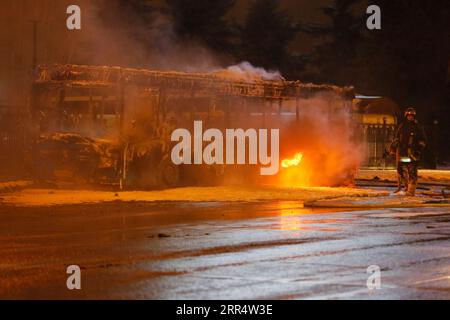 201214 -- MOSKAU, 14. Dezember 2020 -- Ein Feuerwehrmann löscht am 13. Dezember 2020 das Feuer in einem Bus auf einer Straße in Moskau, Russland. Ein Stadtbus brannte aus unbekannten Gründen auf dem Weg zu einem Busdepot in Moskau. Es wurden keine Verluste gemeldet. Foto von /Xinhua RUSSIA-MOSCOW-BUS FIRE AlexanderxZemlianichenkoxJr PUBLICATIONxNOTxINxCHN Stockfoto