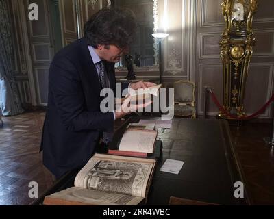 201214 -- PEKING, 14. Dezember 2020 -- Olivier Bosc, Direktor des Arsenalgeländes der Französischen Nationalbibliothek, betrachtet am 27. November 2019 ein antikes Buch in Paris, Frankreich. Xinhua-Schlagzeilen: Altes Buch belebt den modernen China-Frankreich-Kulturaustausch HanxQian PUBLICATIONxNOTxINxCHN Stockfoto