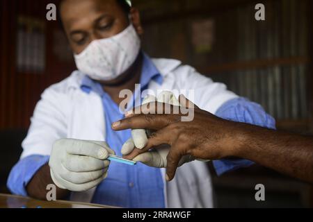 201214 -- AGARTALA, 14. Dezember 2020 -- Ein Gesundheitsarbeiter testet Blut eines Fahrers an einem Busstand während eines Beratungs- und HIV-Testlagers, organisiert von der Tripura State AIDS Control Society in Agartala, der Hauptstadt von Indiens nordöstlichem Bundesstaat Tripura, am 14. Dezember 2020. STR/Xinhua INDIA-AGARTALA-BERATUNG UND HIV-TESTCAMP Stringer PUBLICATIONxNOTxINxCHN Stockfoto