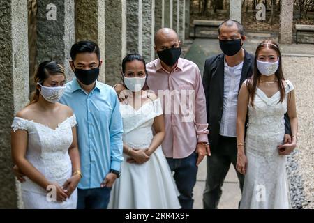 201215 -- MAKATI, 15. Dezember 2020 -- Paare, die Gesichtsmasken tragen, werden während einer maskierten Hochzeit in einem Park in Makati City, Philippinen, 15. Dezember 2020 gesehen. Die philippinische Regierung hat eine strengere Politik der Gesichtsbedeckung auferlegt, da sie befürchtet, dass es während der Weihnachtszeit zu einem möglichen Anstieg der Fälle kommen könnte. PHILIPPINEN-MAKATI-MASSE MASKIERTE HOCHZEIT RouellexUmali PUBLICATIONxNOTxINxCHN Stockfoto