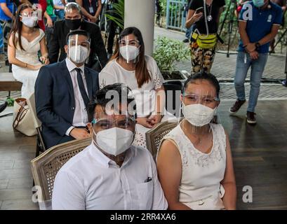 201215 -- MAKATI, 15. Dezember 2020 -- Paare, die Gesichtsmasken und Schilde tragen, werden während einer maskierten Hochzeit in einem Park in Makati City, Philippinen, 15. Dezember 2020 gesehen. Die philippinische Regierung hat eine strengere Politik der Gesichtsbedeckung auferlegt, da sie befürchtet, dass es während der Weihnachtszeit zu einem möglichen Anstieg der Fälle kommen könnte. PHILIPPINEN-MAKATI-MASSE MASKIERTE HOCHZEIT RouellexUmali PUBLICATIONxNOTxINxCHN Stockfoto