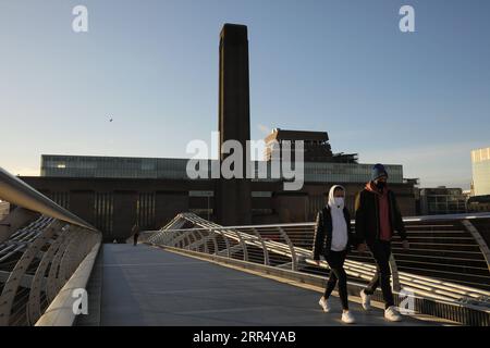 201217 -- LONDON, 17. Dezember 2020 -- Menschen gehen auf der Millennium Bridge, mit der geschlossenen Tate Modern dahinter, in London, Großbritannien, am 16. Dezember 2020. London wechselte ab Mittwoch um Mitternacht in die Stufe 3, die höchste Stufe im lokalen Coronavirus-Beschränkungssystem Englands. Foto: /Xinhua BRITAIN-LONDON-COVID-19-TIER 3 TimxIreland PUBLICATIONxNOTxINxCHN Stockfoto