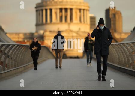 201217 -- LONDON, 17. Dezember 2020 -- Menschen gehen auf der Millennium Bridge bei Sonnenaufgang in London, Großbritannien, am 16. Dezember 2020. London wechselte ab Mittwoch um Mitternacht in die Stufe 3, die höchste Stufe im lokalen Coronavirus-Beschränkungssystem Englands. Foto: /Xinhua BRITAIN-LONDON-COVID-19-TIER 3 TimxIreland PUBLICATIONxNOTxINxCHN Stockfoto