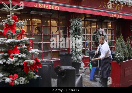 201217 -- LONDON, 17. Dezember 2020 -- Ein Arbeiter reinigt am 16. Dezember 2020 vor einem Restaurant in London, Großbritannien, Mülltonnen. London wechselte ab Mittwoch um Mitternacht in die Stufe 3, die höchste Stufe im lokalen Coronavirus-Beschränkungssystem Englands. Foto: /Xinhua BRITAIN-LONDON-COVID-19-TIER 3 TimxIreland PUBLICATIONxNOTxINxCHN Stockfoto