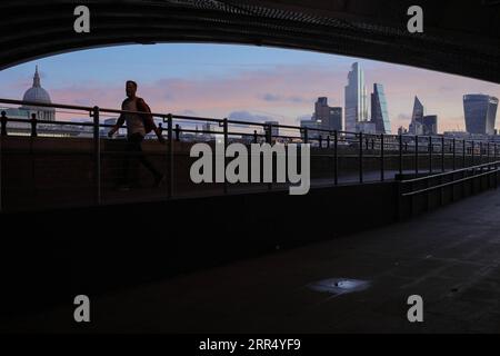 201217 -- LONDON, 17. Dezember 2020 -- Eine Person spaziert am Südufer der Themse bei Sonnenaufgang in London, Großbritannien, am 16. Dezember 2020. London wechselte ab Mittwoch um Mitternacht in die Stufe 3, die höchste Stufe im lokalen Coronavirus-Beschränkungssystem Englands. Foto: /Xinhua BRITAIN-LONDON-COVID-19-TIER 3 TimxIreland PUBLICATIONxNOTxINxCHN Stockfoto