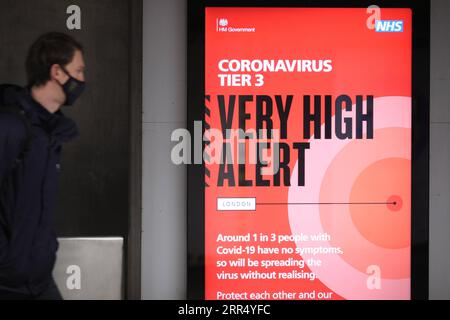 201217 -- LONDON, 17. Dezember 2020 -- Eine Person geht am 16. Dezember 2020 an einem Schild der Waterloo U-Bahnstation in London, Großbritannien vorbei. London wechselte ab Mittwoch um Mitternacht in die Stufe 3, die höchste Stufe im lokalen Coronavirus-Beschränkungssystem Englands. Foto: /Xinhua BRITAIN-LONDON-COVID-19-TIER 3 TimxIreland PUBLICATIONxNOTxINxCHN Stockfoto