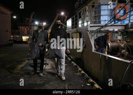 201218 -- PIRÄUS, 18. Dezember 2020 -- Lefteris Arapakis L und sein Kollege sammeln Kunststoffabfälle von Fischern im Hafen von Keratsini, einem Hafenvorort von Piräus, Griechenland, 17. Dezember 2020. Mit der Vision, das Ökosystem nachhaltig zu gestalten, gründete Lefteris Arapakis 2016 Enaleia, ein soziales Start-up, das die Wiederverwertung und Aufbereitung von maritimen Kunststoffabfällen unterstützt. Für seine innovative Idee und seine konsequenten Bemühungen um einen nachhaltigen Umweltwandel wurde der 26-Jährige Anfang dieser Woche als einer der sieben jungen Weltmeister des UN-Umweltprogramms für 2020 zusammen mit chinesischem Umweltschutzprogramm ausgezeichnet Stockfoto