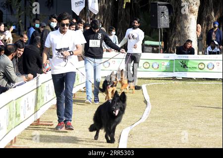 201220 -- RAWALPINDI, 20. Dez. 2020 -- am 20. Dez. 2020 nehmen die Menschen mit ihren Hunden an der All Breed Dog Show in Rawalpindi in der pakistanischen Provinz Punjab Teil. Die All Breed Dog Show fand am Sonntag statt und zog viele Teilnehmer an, ihre Hunde zu zeigen. PAKISTAN-RAWALPINDI-HUNDESHOW AhmadxKamal PUBLICATIONxNOTxINxCHN Stockfoto