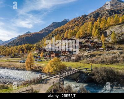 Blatten, Schweiz - 19. Oktober. 2022: Alpendorf mit handwerklichen Holzchalets im Herbst auf dem Lärchenwaldhang im Loetschental, ca. Stockfoto