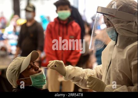 201222 -- JAKARTA, 22. Dezember 2020 -- Ein Mitarbeiter des Gesundheitswesens nimmt eine Nasentupferprobe eines Zuggängers, um am Bahnhof Pasar Senen in Jakarta, Indonesien, 22. Dezember 2020 auf COVID-19 zu testen. Die COVID-19-Fälle in Indonesien stiegen in den letzten 24 Stunden um 6.347 auf 678.125, wobei die Zahl der Todesopfer um 172 auf 20.257, sagte das Gesundheitsministerium am Dienstag. INDONESIEN-JAKARTA-COVID-19-FÄLLE AGUNGXKUNCAHYAXB. PUBLICATIONxNOTxINxCHN Stockfoto