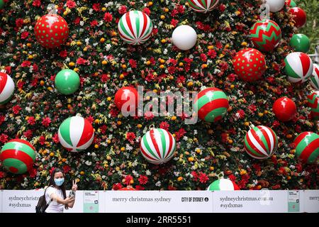 201223 -- PEKING, 23. Dezember 2020 -- Eine Frau mit einer Gesichtsmaske nimmt Selfies vor einem Weihnachtsbaum am Martin Place in Sydney, Australien, 22. Dezember 2020. XINHUA FOTOS DES TAGES BaixXuefei PUBLICATIONxNOTxINxCHN Stockfoto