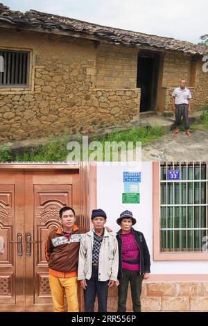 201222 -- HAIKOU, 22. Dez. 2020 -- NACH OBEN: Foto aus dem Jahr 2016 zeigt den Dorfbewohner Wang Minghua, der mit seinem alten Haus im Dorf Baorui im Kreis Qiongzhong in der südchinesischen Provinz Hainan posiert. UNTEN: Foto aufgenommen am 17. Dezember 2020 von zeigt den Dorfbewohner Wang Minghua C und seine Familienmitglieder, die mit ihrem neuen Zuhause im Dorf Baorui posieren. Besucher werden wahrscheinlich von brandneuen Wohnhäusern und glatten asphaltierten Straßen beeindruckt sein, wenn sie das Dorf Baorui in der Provinz Hainan besuchen. Aber eine solche Szene ist kaum vorstellbar im Jahr 2017, als die Menschen der Li-ethnischen Gruppe, die hier lebten, größtenteils in Armut steckten und mich lebten Stockfoto