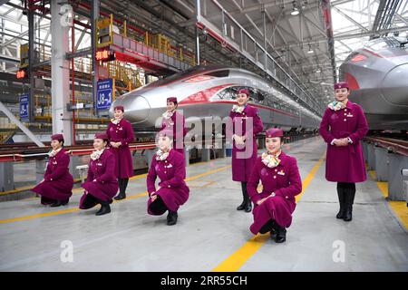 201223 -- CHONGQING, 23. Dezember 2020 -- Besatzungsmitglieder des ersten Betriebs des Fuxing-Hochgeschwindigkeitszuges CR400AF posieren für Fotos vor den Zügen an einer Wartungsstation des Bahnbetriebswerks in der westchinesischen Gemeinde Chongqing, 23. Dezember 2020. Der Fuxing-Hochgeschwindigkeitszug CR400AF, der erstmals der Chongqing Railway zugewiesen wurde, debütierte am Mittwoch in Chongqing und soll am Donnerstag mit dem Zug vom Bahnhof Shapingba in Chongqing zum Bahnhof Chengdu East in Chengdu in der westchinesischen Provinz Sichuan in Betrieb genommen werden. Die Fahrt zwischen den beiden Städten wird von 78 Minuten auf 62 Minuten verkürzt Stockfoto