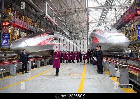 201223 -- CHONGQING, 23. Dezember 2020 -- Crew-Mitglieder des ersten Betriebs des Fuxing-Hochgeschwindigkeitszuges CR400AF debütieren zusammen mit den Zügen an einer Wartungsstation des Bahnbetriebswerks in der westchinesischen Gemeinde Chongqing, 23. Dezember 2020. Der Fuxing-Hochgeschwindigkeitszug CR400AF, der erstmals der Chongqing Railway zugewiesen wurde, debütierte am Mittwoch in Chongqing und soll am Donnerstag mit dem Zug vom Bahnhof Shapingba in Chongqing zum Bahnhof Chengdu East in Chengdu in der westchinesischen Provinz Sichuan in Betrieb genommen werden. Die Fahrt zwischen den beiden Städten wird von 78 Minuten auf 62 Minuten verkürzt. Stockfoto