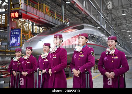 201223 -- CHONGQING, 23. Dezember 2020 -- Besatzungsmitglieder des ersten Betriebs des Fuxing-Hochgeschwindigkeitszuges CR400AF posieren für Fotos vor dem Zug an einer Wartungsstation des Bahnbetriebswerks in der westchinesischen Gemeinde Chongqing, 23. Dezember 2020. Der Fuxing-Hochgeschwindigkeitszug CR400AF, der erstmals der Chongqing Railway zugewiesen wurde, debütierte am Mittwoch in Chongqing und soll am Donnerstag mit dem Zug vom Bahnhof Shapingba in Chongqing zum Bahnhof Chengdu East in Chengdu in der westchinesischen Provinz Sichuan in Betrieb genommen werden. Die Fahrt zwischen den beiden Städten wird von 78 Minuten auf 62 Minuten verkürzt Stockfoto