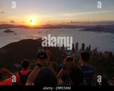 201223 -- HONGKONG, 23. Dezember 2020 -- Menschen beobachten Sonnenuntergang in Hongkong, Südchina, 20. Juni 2020. CHINA-HONGKONG-STADT VIEWCN LixGang PUBLICATIONxNOTxINxCHN Stockfoto