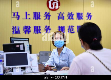 201225 -- PEKING, 25. Dezember 2020 -- A Woman R zieht Wohngeld in einem Bürgerservicezentrum in Fuzhou, südöstliche chinesische Provinz Fujian, 15. Juli 2020 zurück. Jahresende CHINA-JAHR DES 2020-MÄSSIG WOHLHABENDEN SOCIETYCN WeixPeiquan PUBLICATIONxNOTxINxCHN Stockfoto