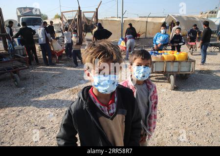 201226 -- BAGDAD, 26. Dez. 2020 -- Kinder mit Masken werden vor dem Treibstoffvertrieb im Hasansham U3 Camp in der Provinz Ninive, Irak, 8. Dez. 2020 gesehen. Die anhaltende COVID-19-Pandemie hat die Anfälligkeit der Binnenvertriebenen im Irak erhöht. Die Hilfsorganisationen können nicht so viel dafür tun, und die Eindämmung des ansteckenden Virus in den Lagern wird immer schwieriger. IRAK-BAGDAD-COVID-19-IDP-LAGER Xinhua PUBLICATIONxNOTxINxCHN Stockfoto