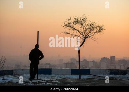 201229 -- PEKING, 29. Dez. 2020 -- Ein Mann schaut sich Smog-ummantelte Gebäude in Teheran, Iran, 27. Dez. 2020 an. Foto von /Xinhua XINHUA FOTOS DES TAGES AhmadxHalabisaz PUBLICATIONxNOTxINxCHN Stockfoto