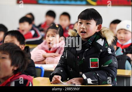 201229 -- BIJIE, 29. Dezember 2020 -- Li Siyu beantwortet Fragen im Unterricht an einer Grundschule in Dafang County, Südwestchinas Provinz Guizhou, 24. Dezember 2020. Li Siyu, 8, und seine 6-jährige Schwester Li Qingyi, lebten früher im Dorf Hetou als Mitglieder eines armutsgeplagten Haushalts. Sie mussten jeden Tag fast eine Stunde zur Schule laufen. Ihre Eltern arbeiteten in anderen Städten, und Li Changde, der 68-jährige Großvater, übernahm die Verantwortung, sie zur Schule und von dort zu bringen. Im Jahr 2019 zog die ganze Familie von Li Changde im Rahmen des Umsiedlungsprojekts zur Armutsbekämpfung um Stockfoto