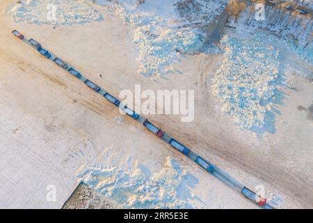 210103 -- HARBIN, 3. Januar 2021 -- Luftaufnahme vom 19. Dezember 2020 zeigt, wie sich Eiswürfeltransporter entlang des gefrorenen Songhua-Flusses in Harbin in der nordöstlichen chinesischen Provinz Heilongjiang aneinanderreihen. Harbin, auch Eisstadt Chinas genannt, zieht Touristen an, indem sie das Eiselement im Winter am besten nutzen. CHINA-HEILONGJIANG-HARBIN-ICE-SNOW-TOURISM CN XIEXJIANFEI PUBLICATIONXNOTXINXCHN Stockfoto