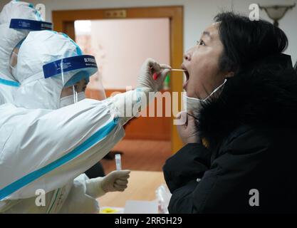 210107 -- SHIJIAZHUANG, 7. Januar 2021 -- Ein medizinischer Mitarbeiter sammelt eine Abstrichprobe von einem Bewohner in einer Gemeinde im Bezirk Yuhua von Shijiazhuang, Hauptstadt der nordchinesischen Provinz Hebei, 7. Januar 2021. Shijiazhuang begann am Mittwoch, stadtweite Nukleinsäuretests durchzuführen, die alle Bewohner abdeckten. CHINA-HEBEI-SHIJIAZHUANG-COVID-19-CITYWIDE TESTS CN JINXHAOYUAN PUBLICATIONXNOTXINXCHN Stockfoto