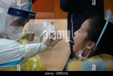 210107 -- SHIJIAZHUANG, 7. Januar 2021 -- Ein medizinischer Arbeiter sammelt eine Abstrichprobe von einem Kind in einer Gemeinde im Bezirk Yuhua von Shijiazhuang, Hauptstadt der nordchinesischen Provinz Hebei, 7. Januar 2021. Shijiazhuang begann am Mittwoch, stadtweite Nukleinsäuretests durchzuführen, die alle Bewohner abdeckten. CHINA-HEBEI-SHIJIAZHUANG-COVID-19-CITYWIDE TESTS CN JINXHAOYUAN PUBLICATIONXNOTXINXCHN Stockfoto