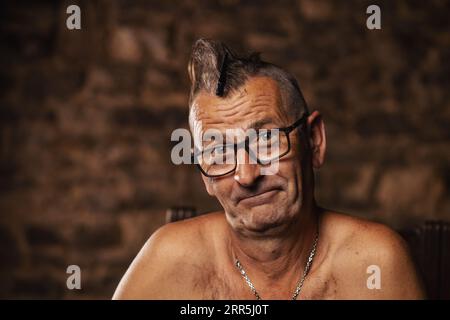 Ein älterer Mann, ein Rentner, der eine Brille mit einem mohawk trägt. Serbische Nationalität, glückliches Gesicht. Stockfoto