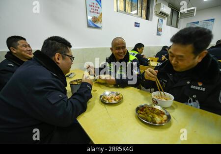 210109 -- CHENGDU, 9. Januar 2021 -- Qiao Zhibing2nd R spricht mit Kollegen während des Mittagessens auf der Jiangxi Street Polizeiwache der Wuhou Bezirksniederlassung des Chengdu Public Security Bureau in Chengdu, südwestchinesische Provinz Sichuan, 8. Januar 2021. Am 10. Januar 2021 ist Chinas erster Tag der chinesischen Volkspolizei, aber für Qiao Zhibing, einen 59-jährigen Polizisten von der Jiangxi Straße Polizeiwache der Wuhou Bezirksniederlassung des Chengdu Public Security Bureau, wird es sein letzter Polizeitag sein, da er im Juni dieses Jahres mit 60 Jahren in Rente gehen wird. Als sich der Tag der chinesischen Volkspolizei nähert, kommen Kollegen von der Stockfoto