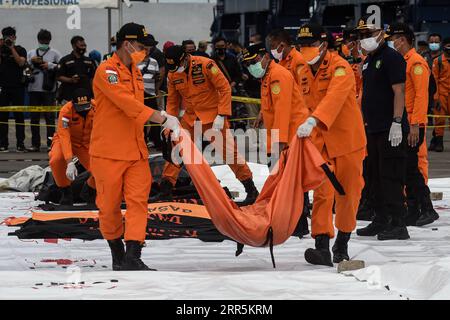 Bilder des Jahres 2021, News 01 Januar News Themen der Woche KW01 News Bilder des Tages 210110 -- JAKARTA, 10. Januar 2021 -- die Mitglieder des indonesischen Such- und Rettungs-SAR-Teams tragen Körperteile von Passagieren an Bord des Sriwijaya Air-Fluges SJ-182 am Tanjung Priok Port, Jakarta, Indonesien, 10. Januar 2021. Die Rettungskräfte sammelten am Sonntag fünf Säcke mit menschlichen Körperteilen und drei Säcke mit Trümmern des Flugzeugs Sriwijaya, das in den Gewässern vor der Küste der indonesischen Hauptstadt Jakarta abstürzte, sagte ein hochrangiger Beamter. Foto von /Xinhua INDONESIA-JAKARTA-FLUGZEUGABSTURZ-SUCHE AgungxKuncahyaxB. PUBLICATIONxNO Stockfoto