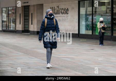 210110 -- LONDON, 10. Januar 2021 -- Eine Frau, die Eine Gesichtsmaske trägt, läuft an einem Supermarkt in London, Großbritannien, 10. Januar 2020 vorbei. Die Coronavirus-bedingten Todesfälle in Großbritannien übertrafen am Samstag 80.000, weitere 1.035 wurden im Land gemeldet. GROSSBRITANNIEN-LONDON-COVID-19-FÄLLE HanxYan PUBLICATIONxNOTxINxCHN Stockfoto