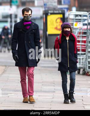 210110 -- LONDON, 10. Januar 2021 -- Menschen mit Gesichtsmasken gehen auf einer Straße in London, Großbritannien, 10. Januar 2021. Die Coronavirus-bedingten Todesfälle in Großbritannien übertrafen am Samstag 80.000, weitere 1.035 wurden im Land gemeldet. GROSSBRITANNIEN-LONDON-COVID-19-FÄLLE HanxYan PUBLICATIONxNOTxINxCHN Stockfoto