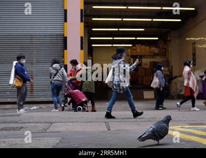 210110 -- HONG KONG, 10. Januar 2021 -- Menschen mit Gesichtsmasken gehen auf einer Straße im südchinesischen Hongkong, 10. Januar 2021. Das Zentrum für Gesundheitsschutz in Hongkong (CHP) meldete am Sonntag 31 weitere bestätigte COVID-19-Fälle und erreichte damit insgesamt 9.242 Fälle. CHINA-HONG KONG-COVID-19-FÄLLE LixGang PUBLICATIONxNOTxINxCHN Stockfoto