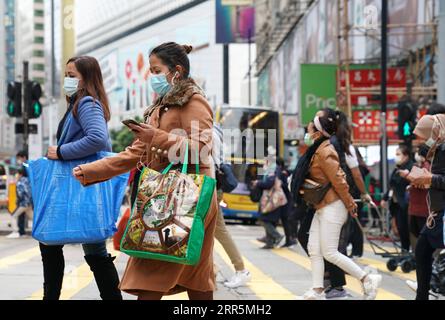 210110 -- HONG KONG, 10. Januar 2021 -- Menschen mit Gesichtsmasken gehen auf einer Straße im südchinesischen Hongkong, 10. Januar 2021. Das Zentrum für Gesundheitsschutz in Hongkong (CHP) meldete am Sonntag 31 weitere bestätigte COVID-19-Fälle und erreichte damit insgesamt 9.242 Fälle. CHINA-HONG KONG-COVID-19-FÄLLE LixGang PUBLICATIONxNOTxINxCHN Stockfoto