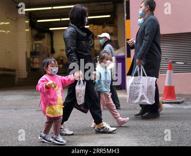 210110 -- HONG KONG, 10. Januar 2021 -- Menschen mit Gesichtsmasken gehen auf einer Straße im südchinesischen Hongkong, 10. Januar 2021. Das Zentrum für Gesundheitsschutz in Hongkong (CHP) meldete am Sonntag 31 weitere bestätigte COVID-19-Fälle und erreichte damit insgesamt 9.242 Fälle. CHINA-HONG KONG-COVID-19-FÄLLE LixGang PUBLICATIONxNOTxINxCHN Stockfoto