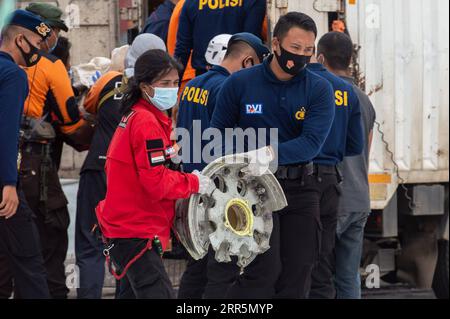 210111 -- JAKARTA, 11. Januar 2021 -- Mitarbeiter tragen Trümmer, die während der Suche im Such- und Rettungskommando am Tanjung Priok Hafen in Jakarta, Indonesien, am 11. Januar 2021 gefunden wurden. Indonesiens Such- und Rettungsteam hat das Einsatzgebiet erweitert, um nach Trümmern und Opfern des Flugzeugabsturzes Sriwijaya mit weiteren Flotten am dritten Tag der Operation zu suchen, sagte die indonesische nationale Such- und Rettungsagentur am Montag. Bis jetzt haben die Offiziere die Trümmer des unglückseligen Flugzeugs und Leichenteile, die Eigentum der Opfer sind, gefunden und den Standort der schwarzen Boxen geschätzt. Stockfoto