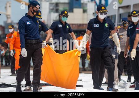 210111 -- JAKARTA, 11. Januar 2021 -- Rettungskräfte tragen einen Beutel mit Körperteilen der Opfer, die aus den Gewässern, in denen Sriwijaya Air Flug SJ-182 abgestürzt ist, am Tanjung Priok Hafen in Jakarta, Indonesien, 11. Januar 2021, geborgen wurden. Indonesiens Such- und Rettungsteam hat das Einsatzgebiet erweitert, um nach Trümmern und Opfern des Flugzeugabsturzes Sriwijaya mit weiteren Flotten am dritten Tag der Operation zu suchen, sagte die indonesische nationale Such- und Rettungsagentur am Montag. Bis jetzt haben die Offiziere die Trümmer des unglückseligen Flugzeugs und Leichenteile Eigentum der Opfer gefunden und haben es getan Stockfoto