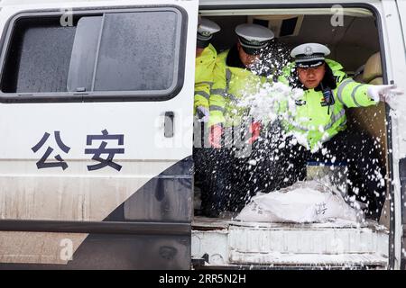 210111 -- PANZHOU, 11. Januar 2021 -- Verkehrspolizisten verbreiten Industriesalz, ein Eisschmelzmittel, auf der Donghu-Brücke in der Stadt Panzhou der Provinz Guizhou im Südwesten Chinas, 11. Januar 2021. Die jüngste starke kalte Welle hat zu Kongelationen in Panzhou und an vielen anderen Orten in Guizhou geführt. Rund 400 Verkehrspolizisten in Panzhou arbeiten nun rund um die Uhr daran, die Straßenflächen der Stadt zu entfernen. Das fluoreszierende Grün auf ihren Jacken scheint die wärmste Farbe in einem frostigen Winter zu sein. CHINA-GUIZHOU-PANZHOU-POLICE-ICE-MELTING CN OUXDONGQU PUBLICATIONXNOTXINXCHN Stockfoto