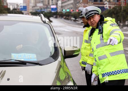 210111 -- PANZHOU, 11. Januar 2021 -- Verkehrspolizisten warnen Fahrer vor nassem und rutschigem Untergrund auf der Donghu-Brücke in der Stadt Panzhou in der südwestlichen chinesischen Provinz Guizhou, 11. Januar 2021. Die jüngste starke kalte Welle hat zu Kongelationen in Panzhou und an vielen anderen Orten in Guizhou geführt. Rund 400 Verkehrspolizisten in Panzhou arbeiten nun rund um die Uhr daran, die Straßenflächen der Stadt zu entfernen. Das fluoreszierende Grün auf ihren Jacken scheint die wärmste Farbe in einem frostigen Winter zu sein. CHINA-GUIZHOU-PANZHOU-POLICE-ICE-MELTING CN OUXDONGQU PUBLICATIONXNOTXINXCHN Stockfoto