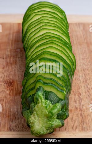 Zucchini in Scheiben auf Bambusschneidebrett. Studio-Aufnahme. Stockfoto